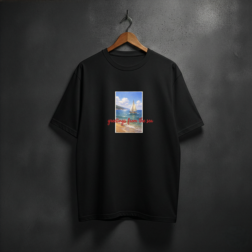 Black t-shirt with a graphic design of a sailboat and text 'greetings from the sea' on the front chest